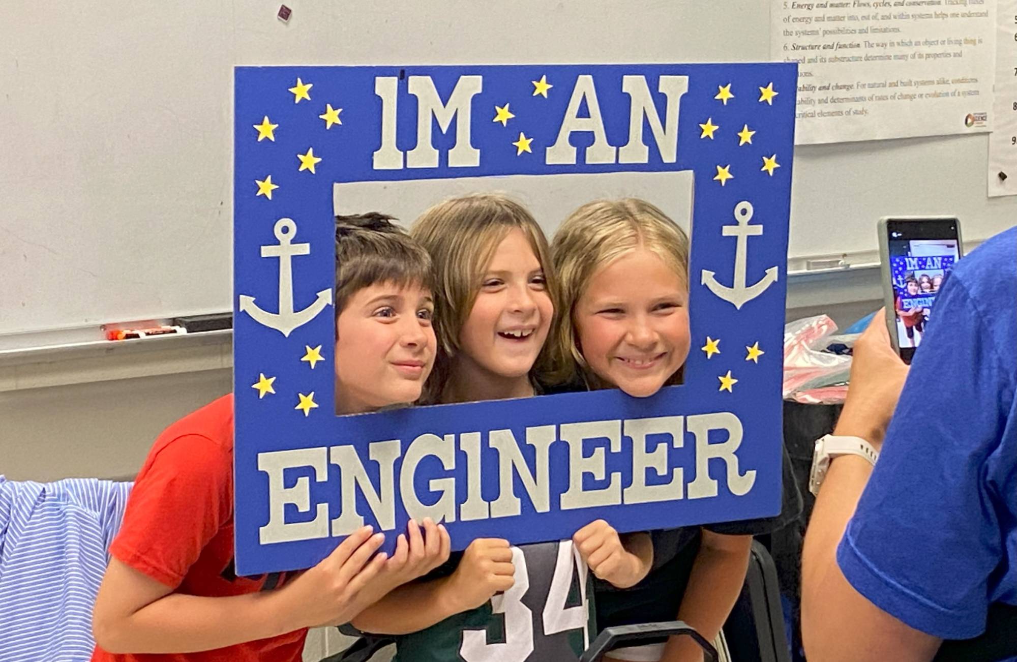 Children posing with engineering sign